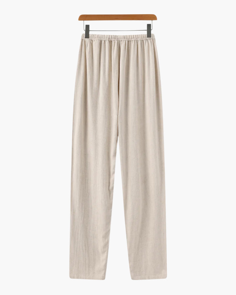 Beige casual loose fit pants with elastic waistband hanging on wooden hanger