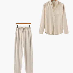 Beige loungewear set with long sleeve button-up shirt and drawstring pants hanging on wooden hangers