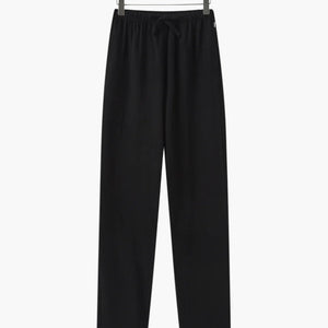Black casual drawstring pants hanging on wooden hanger for comfortable everyday wear