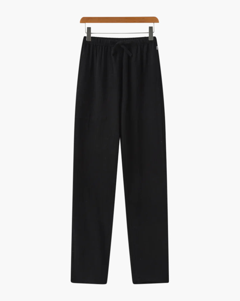 Black casual drawstring pants hanging on wooden hanger for comfortable everyday wear