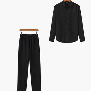 Black long sleeve button-up shirt and matching black drawstring pants set on hangers