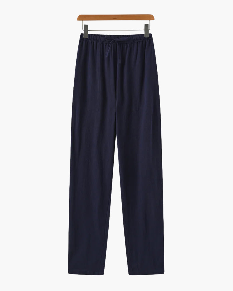 Navy blue casual pants with elastic waistband and drawstring hanging on wooden hanger