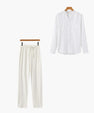 White long sleeve shirt and matching white drawstring pants set on wooden hangers